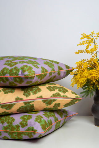 Dar Leone cushions stacked with a mimosa plant