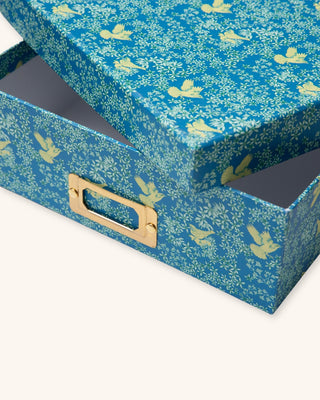 Blue storage box with gold handle and bird pattern on a white background